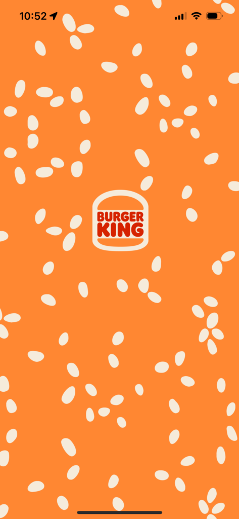 Burger King app launch screen with orange background and sesame seeds.